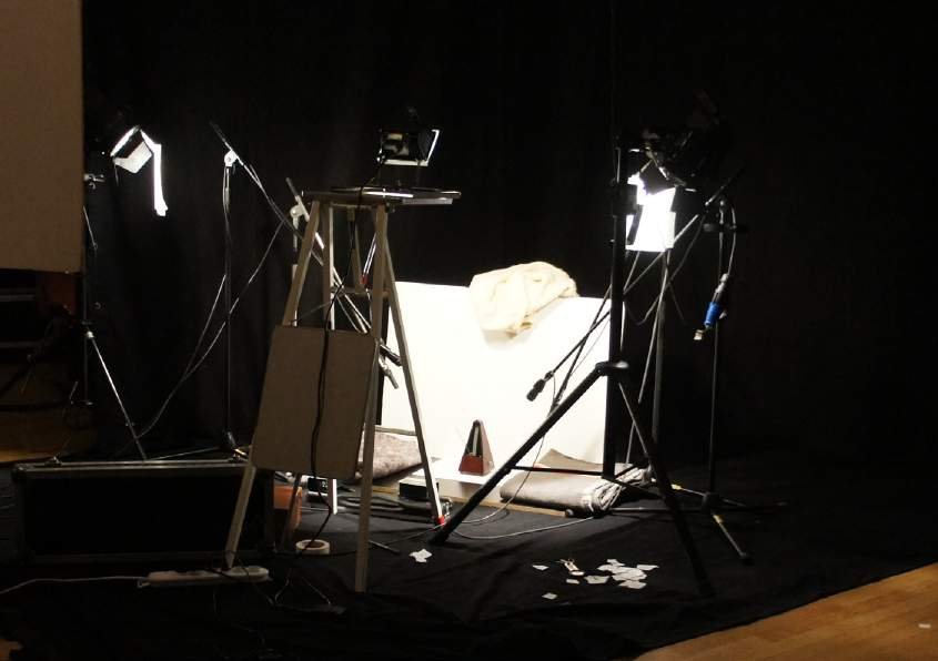 Installation view of the recording: analogue metronome, white screen, 3 spots, 2 microphones, camera – studio of Champ d’Action, Antwerp, 2013
