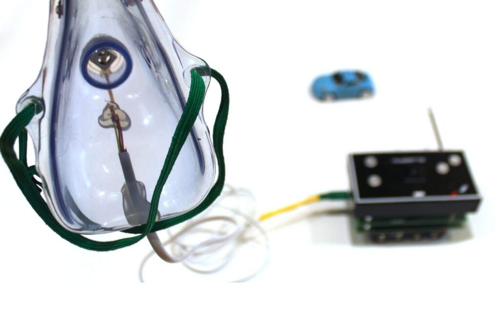Maquette: mask, one mini-fan, cable, remote control and miniature car, made in collaboration with Kris Delacourt, 2013